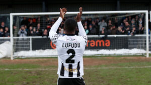 Spennymoor Town defender John Lufudu applauds supporters