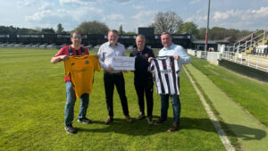 Spennymoor Town's Ian Geldard and Stephen Gilling accept the donation from Ferryhill Athletic officials