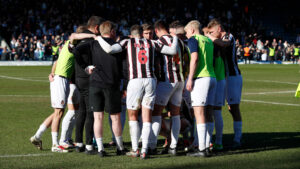Spennymoor Town players and staff form a huddle at Rochdale