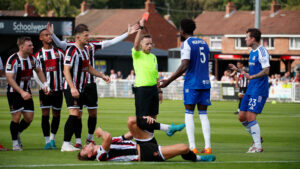 Macclesfield defender Rollin Menayese is shown a red card for a challenge on Spennymoor Town's Glen Taylor